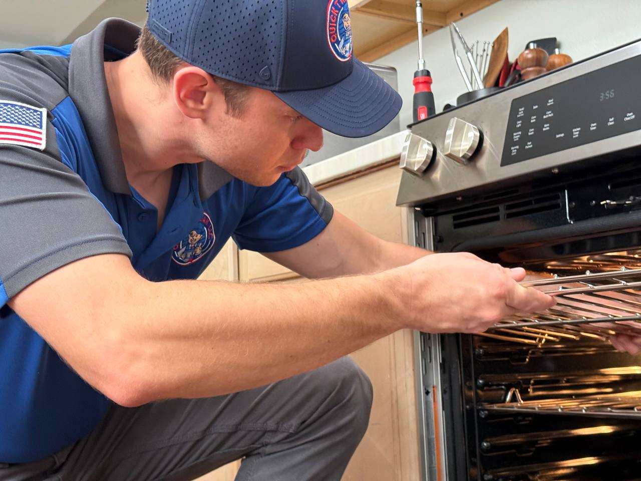 Quick Tweak technician diagnosing an oven repair issue up close