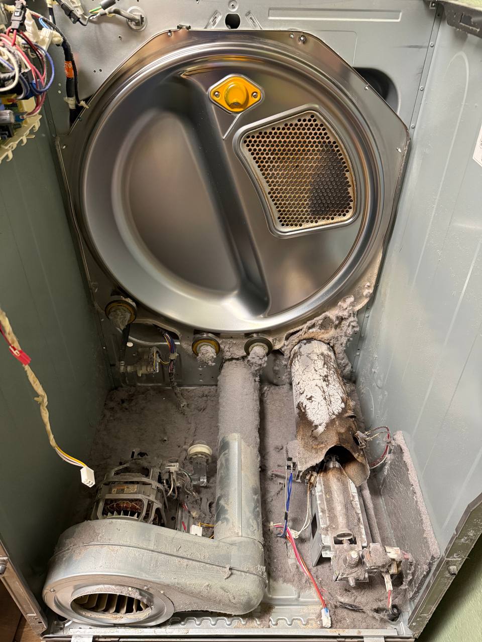 Before dryer repair with heavy lint buildup inside the cabinet
